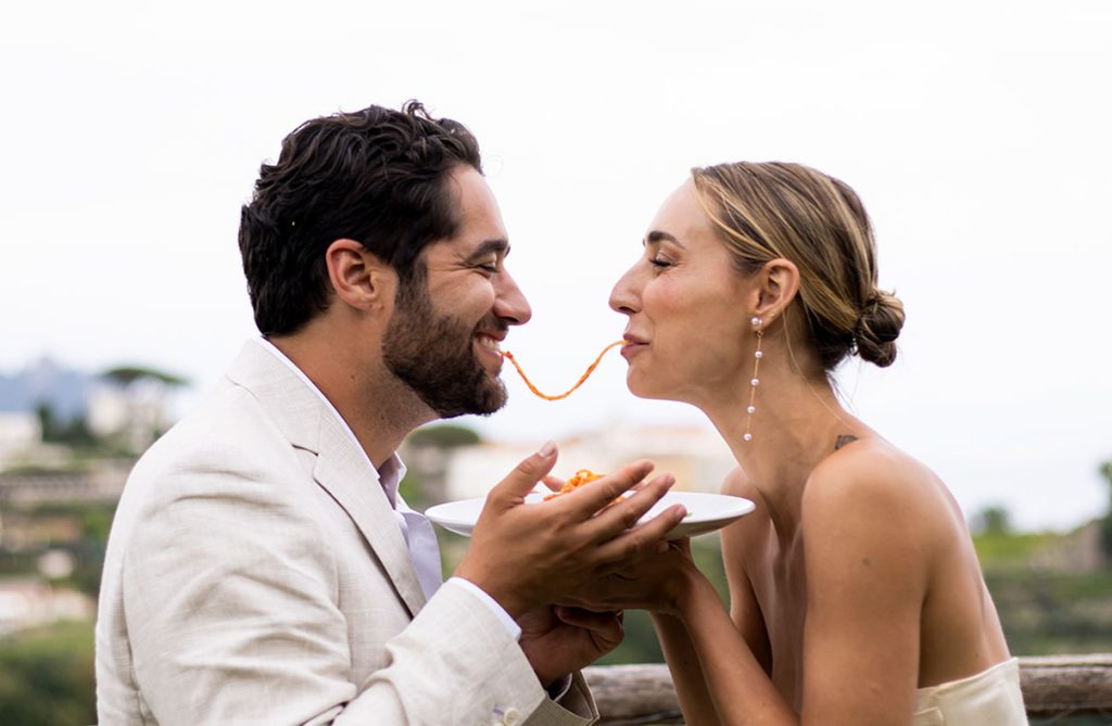 "ALT"fotógrafo en la costa amalfitana comiendo juntos spaguetti"